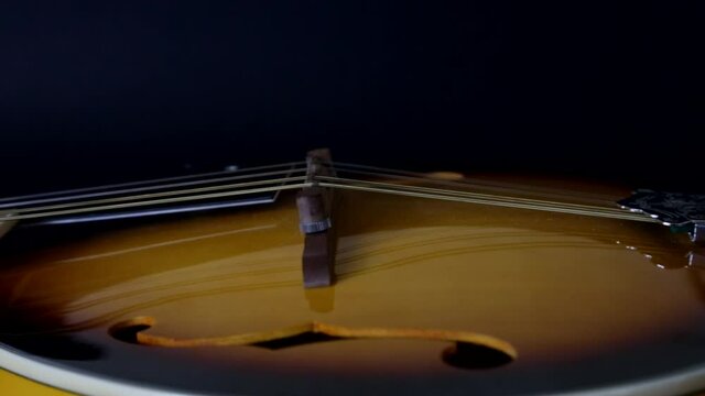 Mandolin, close camera movement on black background. Selective focus.