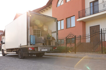 Van full of moving boxes and furniture near house