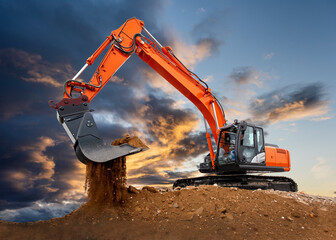 excavator working on construction site with dramatic clouds on sky
