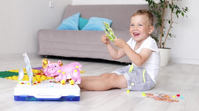 a boy child is playing educational games at home fooling around and smiling