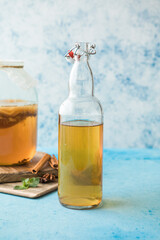 Raw fermented homemade alcoholic or non alcogolic kombucha superfood. Ice tea with healthy natural probiotic in glass with mint on  blue background