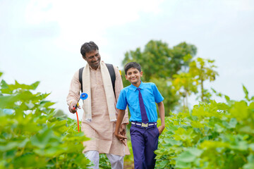 Young indian farmer with his son at green agriculture field. - obrazy, fototapety, plakaty