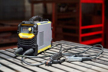 inverter welding machine in the workshop. welding machine on a wooden table