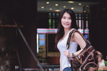 Asian traveling woman with suitcase Wait for check-in at the resort or hotel. travel or vacation concept. Book accommodation, Booking  hotel online. adventure