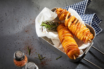 Tasty twist potatoes in metal container on table