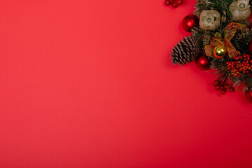 Composition of christmas decorations with pine cones and copy space on red background