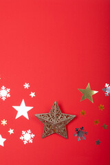 Composition of christmas decorations with stars, snowflakes and copy space on red background