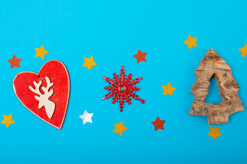 Composition of christmas decorations with heart, stars and copy space on blue background