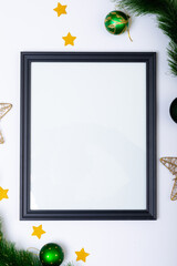 Composition of frame with copy space and fir tree branches with baubles on white background