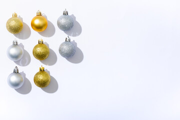 Composition of gold and silver baubles with copy space on white background
