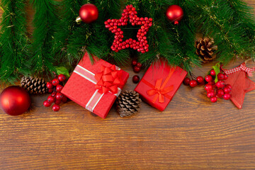 Composition of christmas decorations with baubles, presents and copy space on wooden background