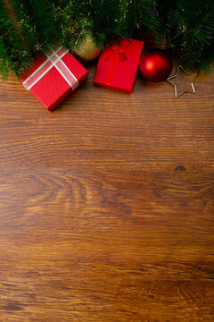 Composition of christmas decorations with presents, baubles and copy space on wooden background