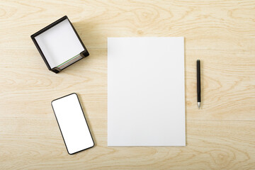 Composition of white card and smartphone with copy space on wooden background