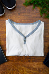 Composition of t-shirt, shoes and tree branches on wooden background