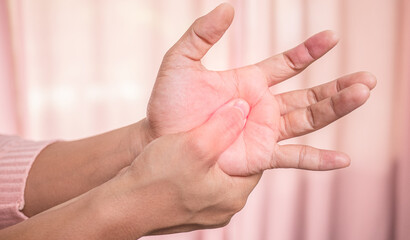 Closeup of female holding her painful palm and numbness caused by prolonged work on the computer or...