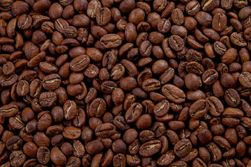 Macro shot of roasted brown coffee beans with a lot of copy space for text. Flat lay composition. Close up, top view, background.