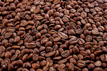 Macro shot of roasted brown coffee beans with a lot of copy space for text. Flat lay composition. Close up, top view, background.