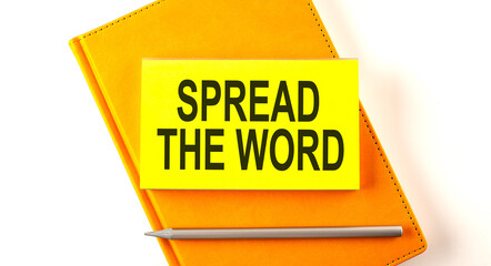 Text SPREAD THE WORD on the sticker on the yellow notebook