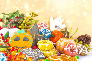 Happy Halloween greeting card background. Trick or treat concept. Traditional gingerbread cookies, candy, sweets, pumpkins, decorations with bokeh lights effect