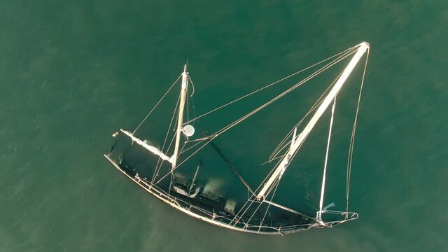Aerial: Sunken yacht in the water at sunset. San Pablo Bay, Oakland, USA