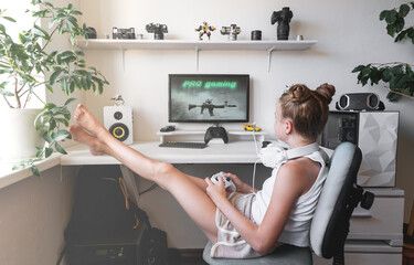 Girl holding white wireless gamepad against white computer dream desk.
