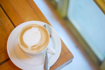 a cup of late coffee with flower shape design on top at cafe 