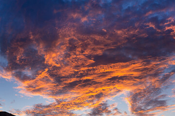 Cloudy sky at sunset with red, orange and blue colors