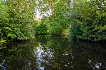 The Knoll, a small park in Hayes, Kent, UK. Reflections on the water of a small lake or pond with trees in The Knoll park. Hayes is in the Borough of Bromley in Greater London.