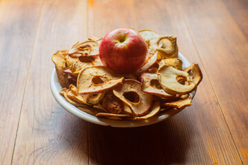 Ripe fresh healthy diet vegetarian food with vitamins. Dried apples in the form of rings on a plate on a wooden surface. Harvesting season.