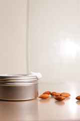 Aluminum round jar for cosmetics with almonds. Metalic cosmetic bottles. Blank mock up advertising container with copy space.