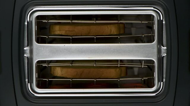 Toaster toasts bread toast to a burnt level, top view, accelerated time-lapse 