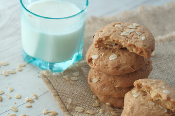 stack of whole meal cookies and glass of milk on table 