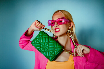 Fashion accessories advertising conception: confident woman holding trendy green quilted leather...