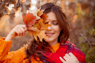 a young woman in an autumn park in an orange sweater
