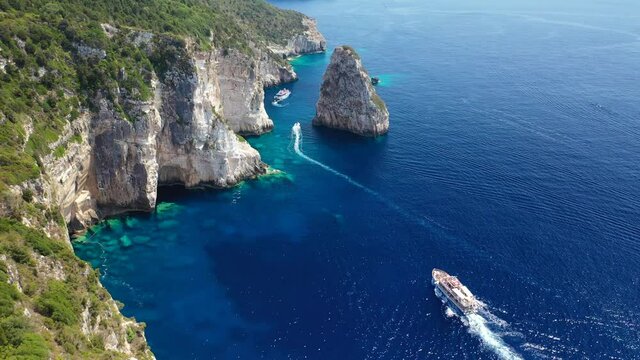 Aerial drone video of iconic Ortholithos and azure caves with deep turquoise sea where submarine Papanikolis was hiding during world war II, Paxos island, Ionian, Greece
