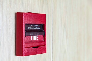 Fire alarm switch on the white wood wall
