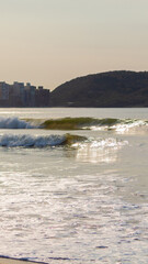 ONDA QUEBRANDO NA PRAIA EM UM AMANHECER.
