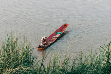 People are fishing on a small fishing boat in the water.