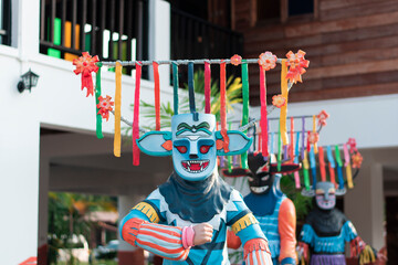 Chiang Khan: Phi Khon Nam puppets stand next to a wooden building.
