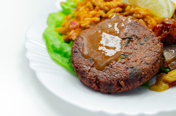 Meat free burger and long grain rice with red peppers, tomatoes and jalapeno chillies