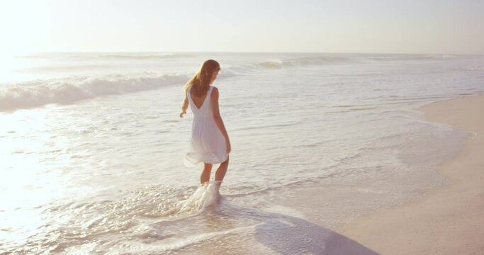 beautiful woman wearing white dress walking on beach at sunset in slow motion RED DRAGON
