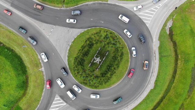 Cars are moving along the roundabout, aerial view, slow counterclockwise rotation
