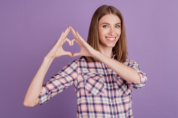 Obraz premium Close-up portrait of cheerful cute attractive lovely girl showing heart gesture isolated over violet background