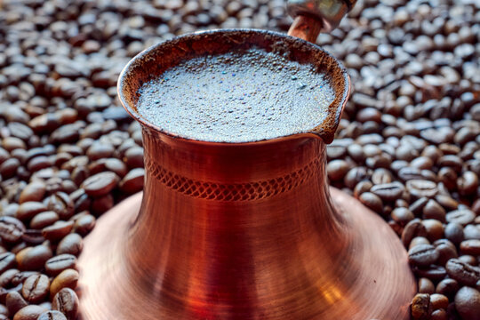 copper cezva with freshly brewed coffee close-up