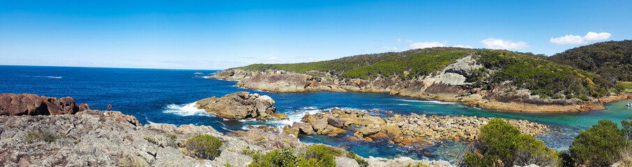 Panoramic shot of a landscape with islands and the blue seascape merged with clear blue sky