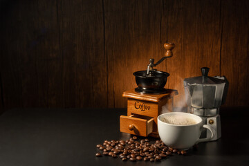suit of moka pot, grinder and coffee cup with coffee beans