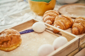 Duck egg in wood bucket and other bakery breads , Croissants on table