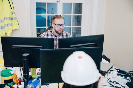 Male building contractor using computer while working in office