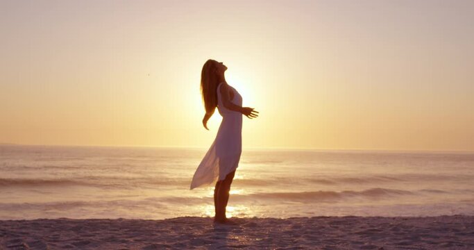 Free happy woman arms outstretched enjoying nature on beach at sunset face raised towards sky slow motion RED DRAGON