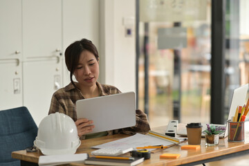 Portrait with young architect woman working with a digital tablet in the modern office.